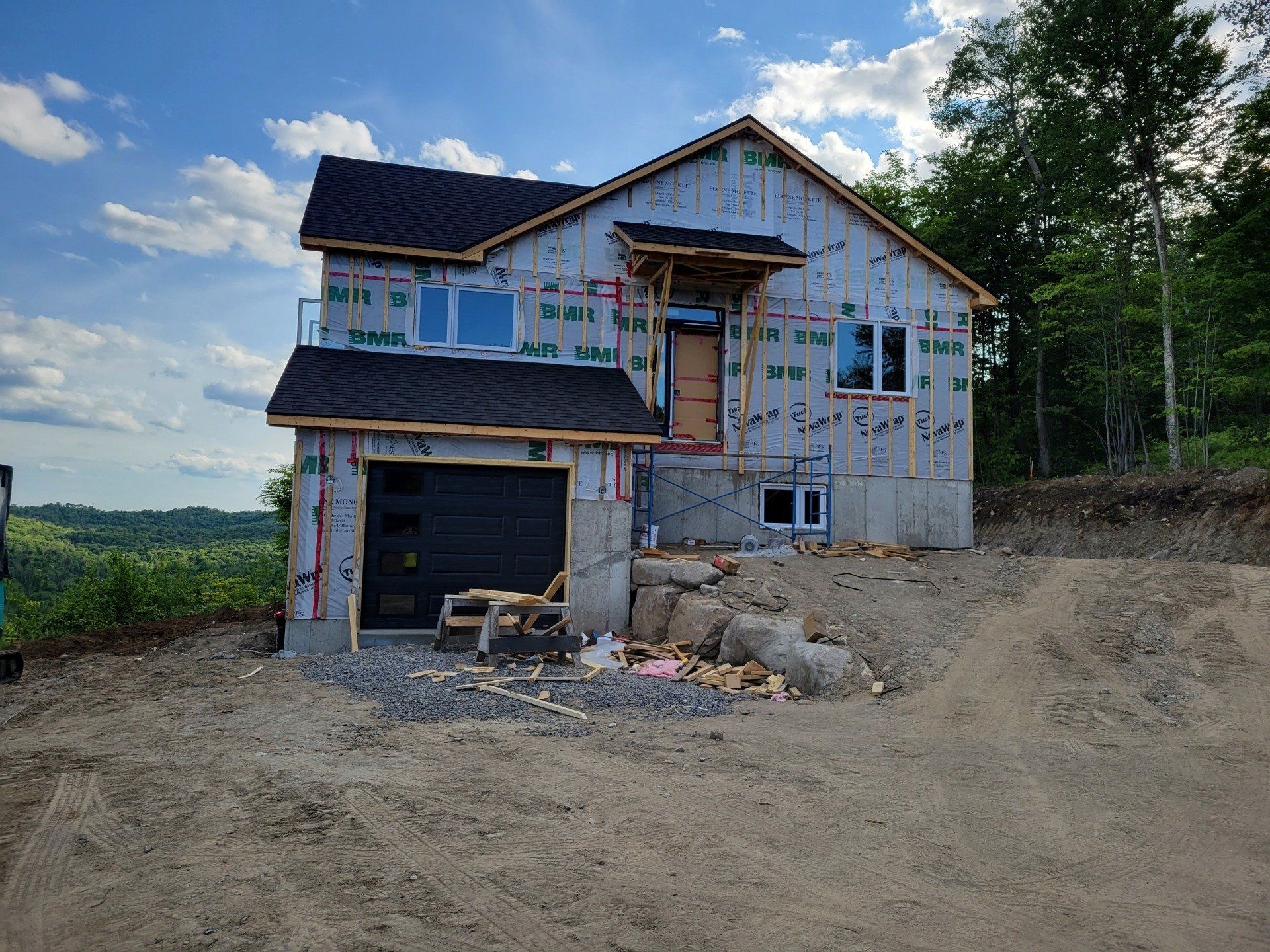 Une maison est en construction au sommet d'une colline de terre.