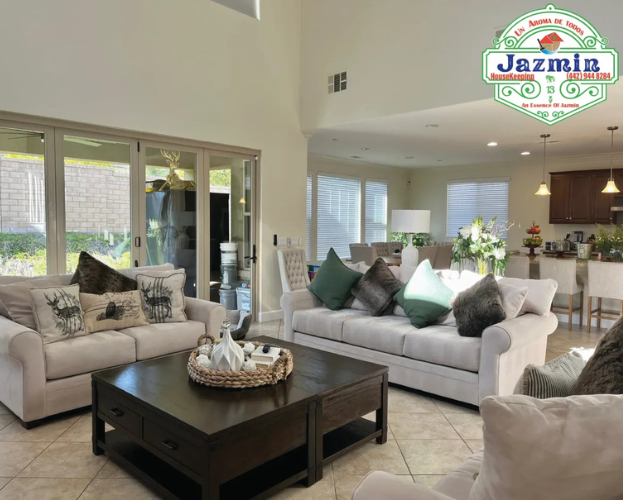 Bright living room with beige sofas, black coffee table, and open view to kitchen and patio