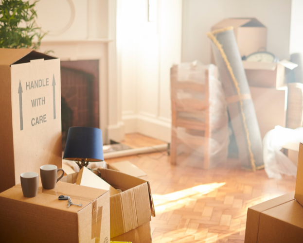 Moving boxes and lamps in a sunlit room, suggesting a home move or unpacking.