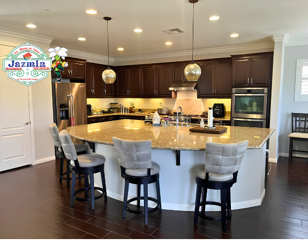 Bright kitchen with dark cabinets, granite island, and four gray bar stools under pendant lights