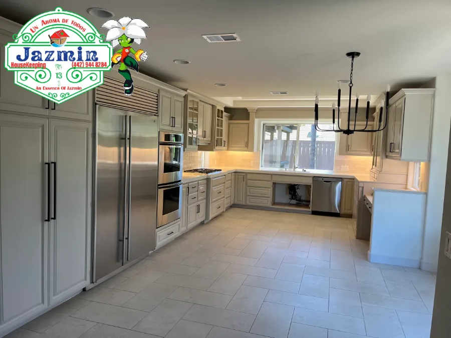 Bright modern kitchen with white cabinets, stainless steel appliances, and tiled floor