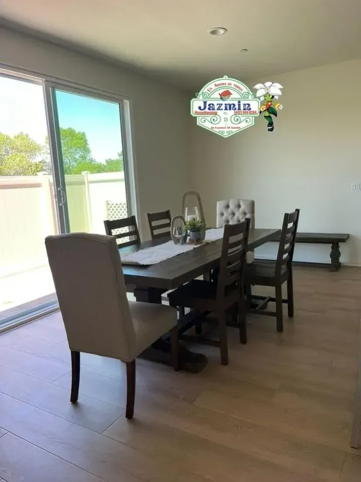 Dining room with dark wood table and chairs beside sliding glass doors, with a bench against the wall.