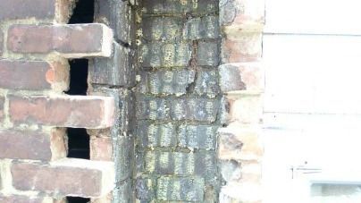 A close up of a brick wall with a hole in it.