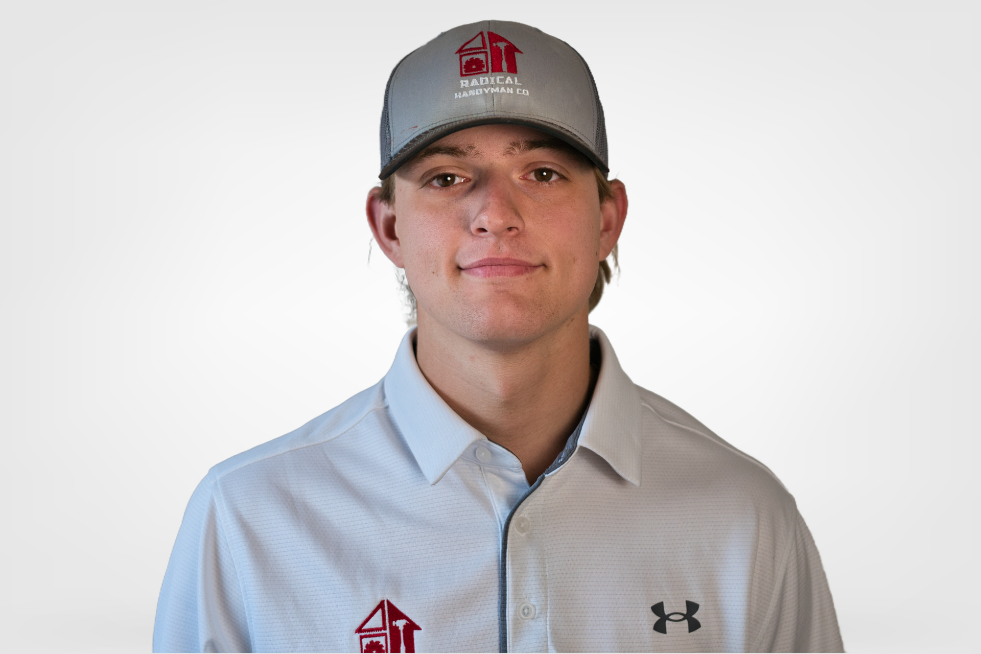 Young person in a gray cap and light button-up shirt, standing against a white background.