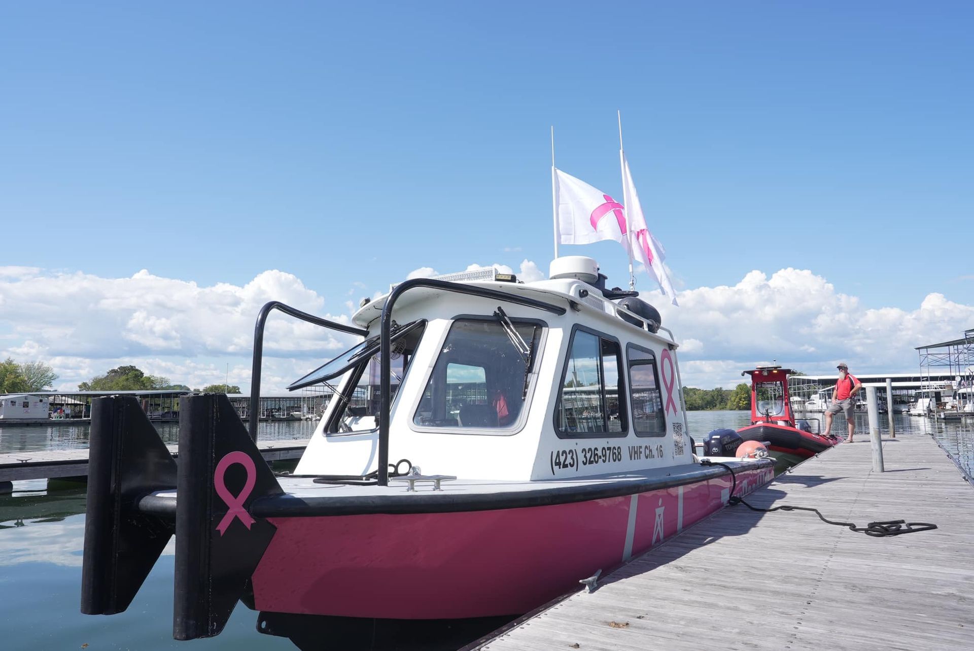 White boat cockpit with cushioned seats, steering wheel, and windshield on the water
