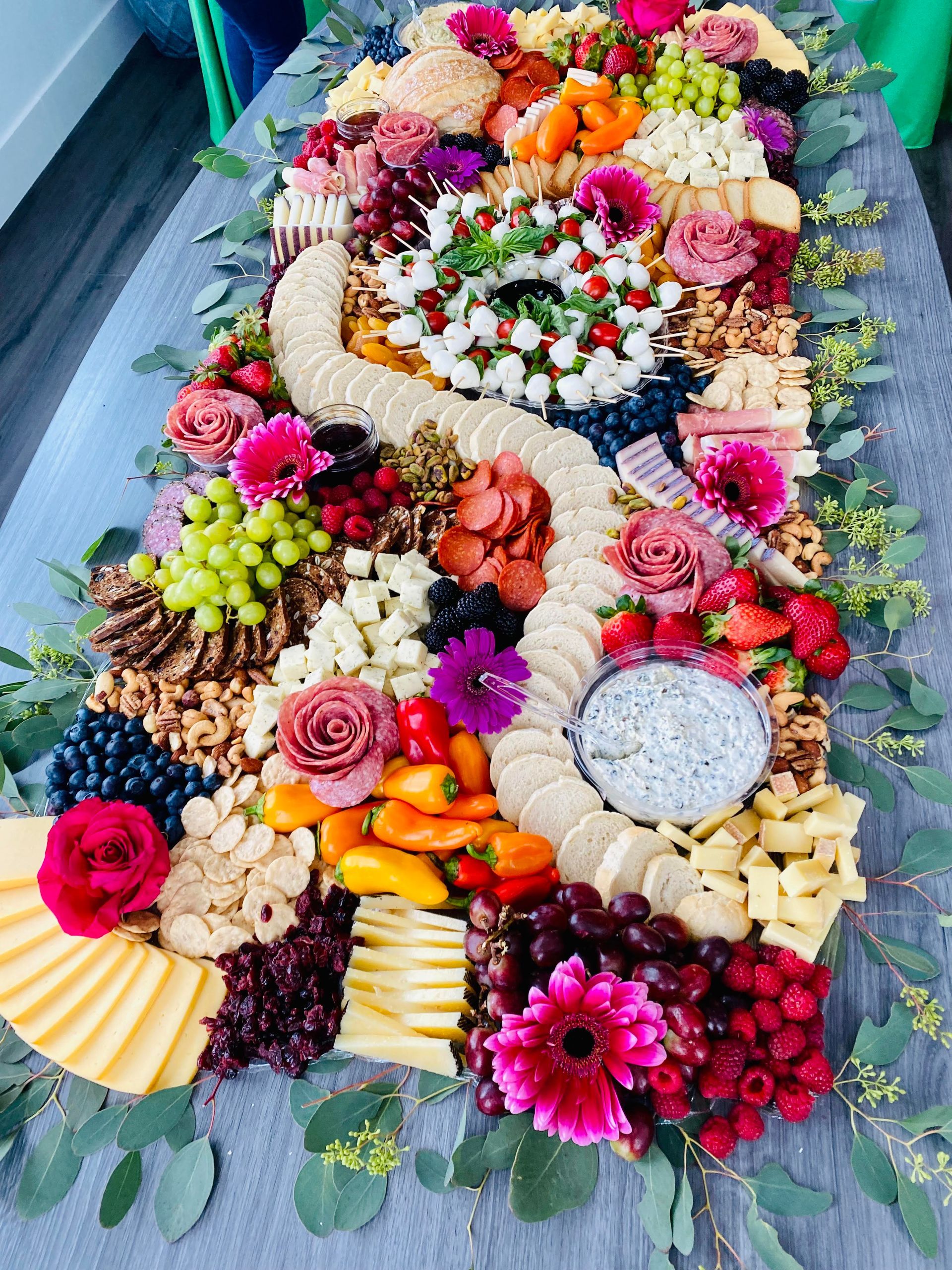A colorful charcuterie board arranged on a gaze table.