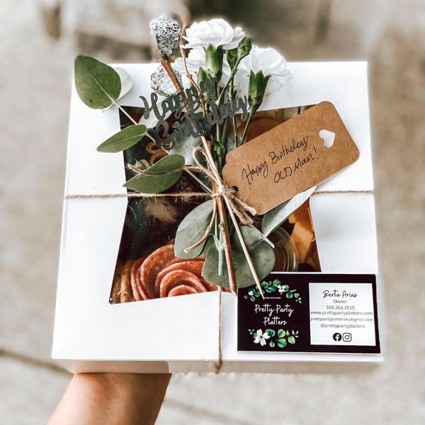 White gift box with window, decorated with flowers and a tag that reads "Happy Birthday Old Man!"