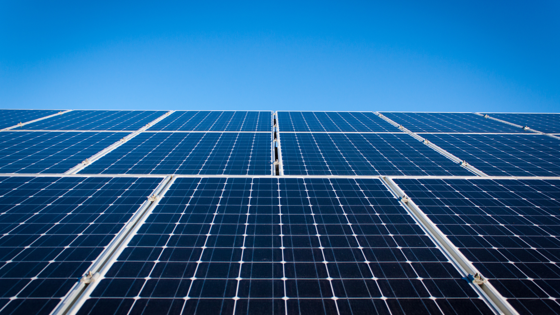 A row of solar panels against a blue sky.