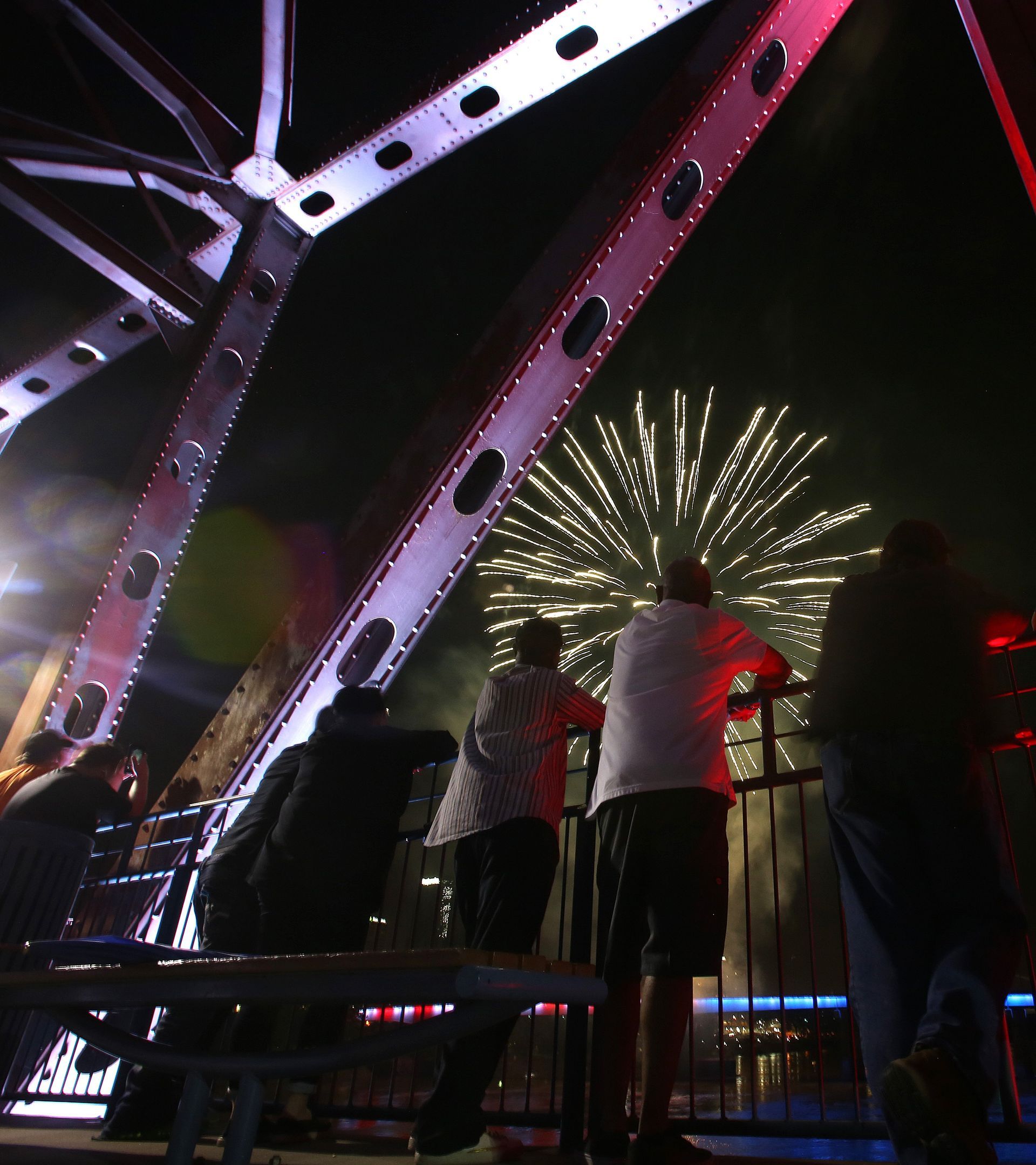 Colorful fireworks bursting in a night sky, with red, blue, and white explosions