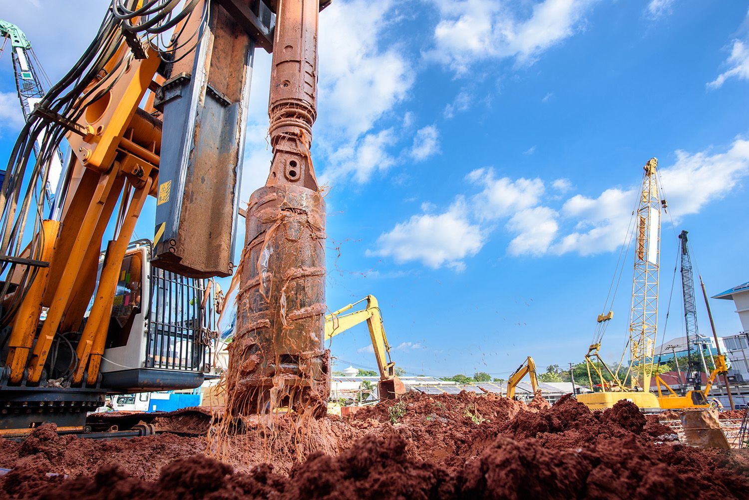 Construction equipment boring into the ground to prepare for pile foundation.