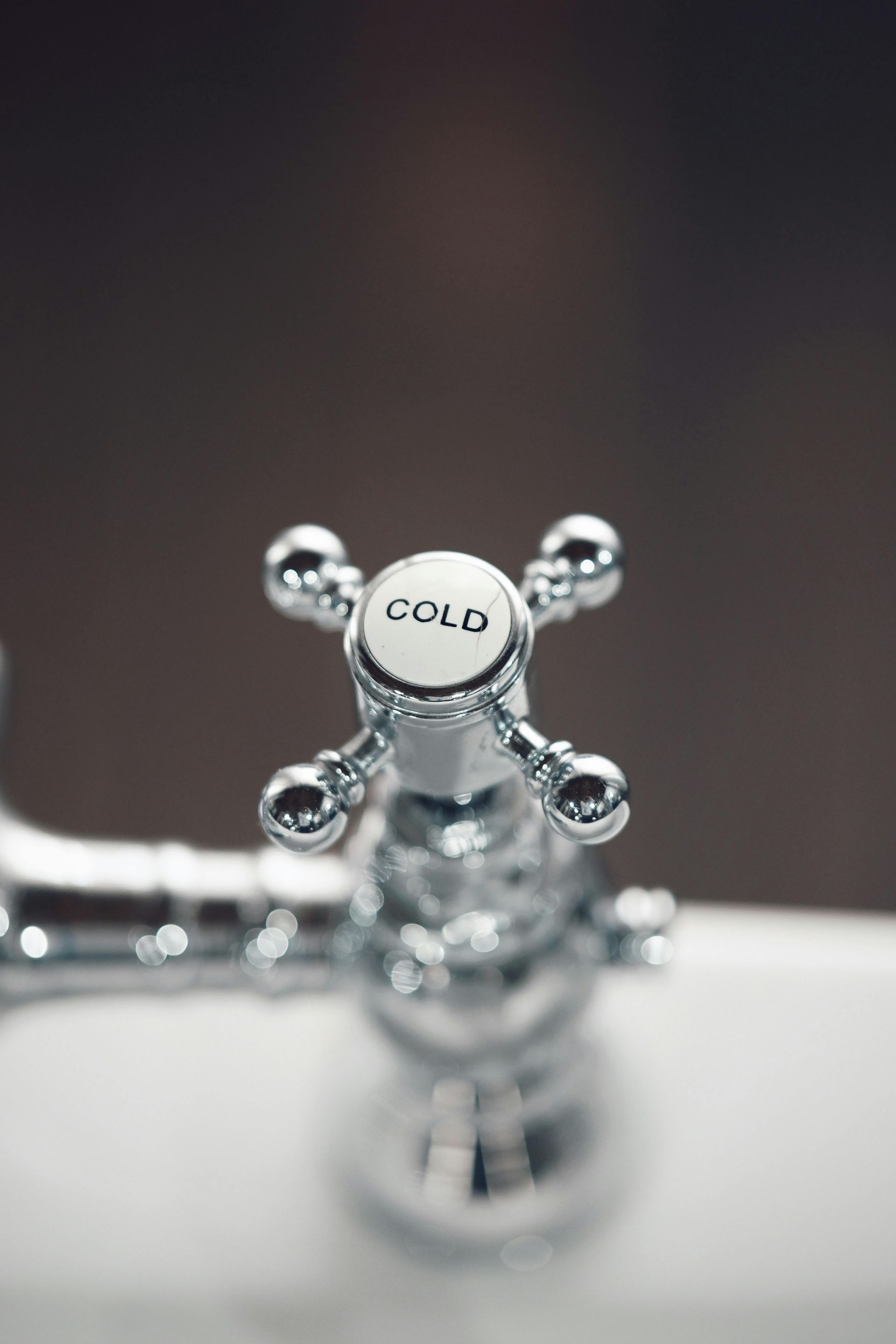 A polished chrome cross-handle faucet labeled 