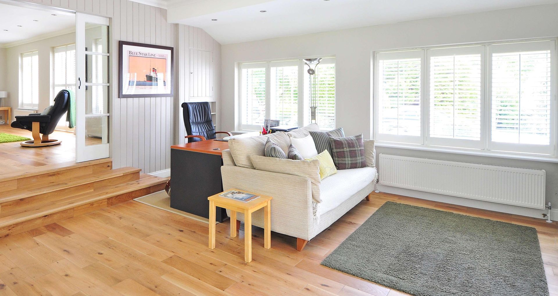 A living room with a couch , chair , table and rug.