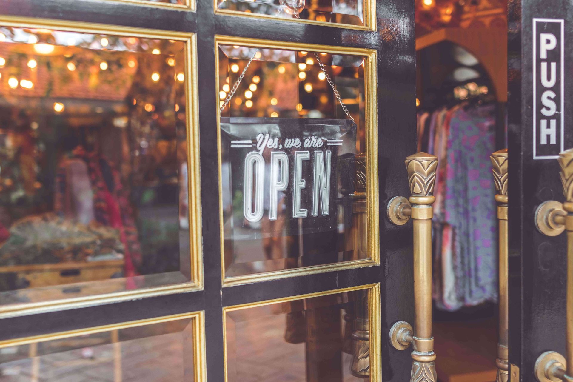 A store front with an open sign on the door.