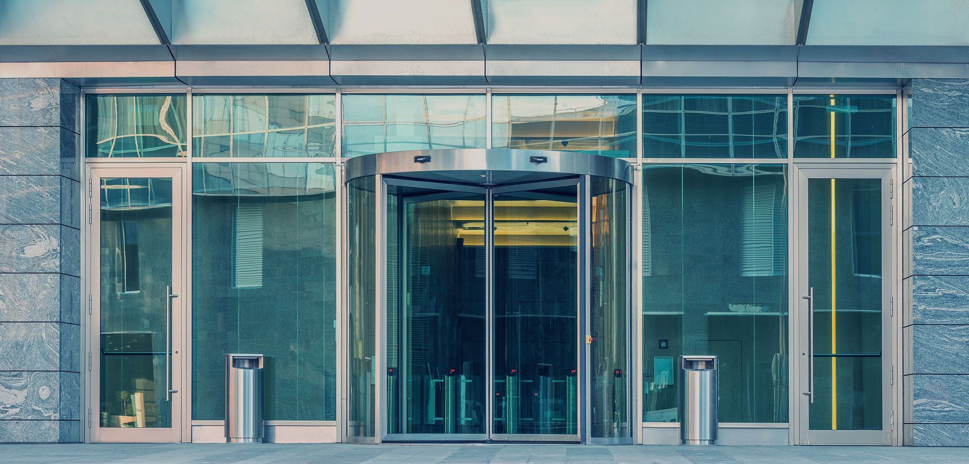 A large building with a lot of glass doors and a revolving door.
