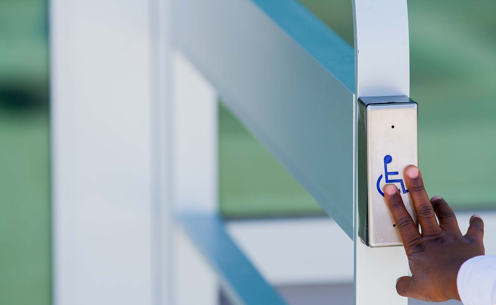 A person is pressing a button with a handicap symbol on it.