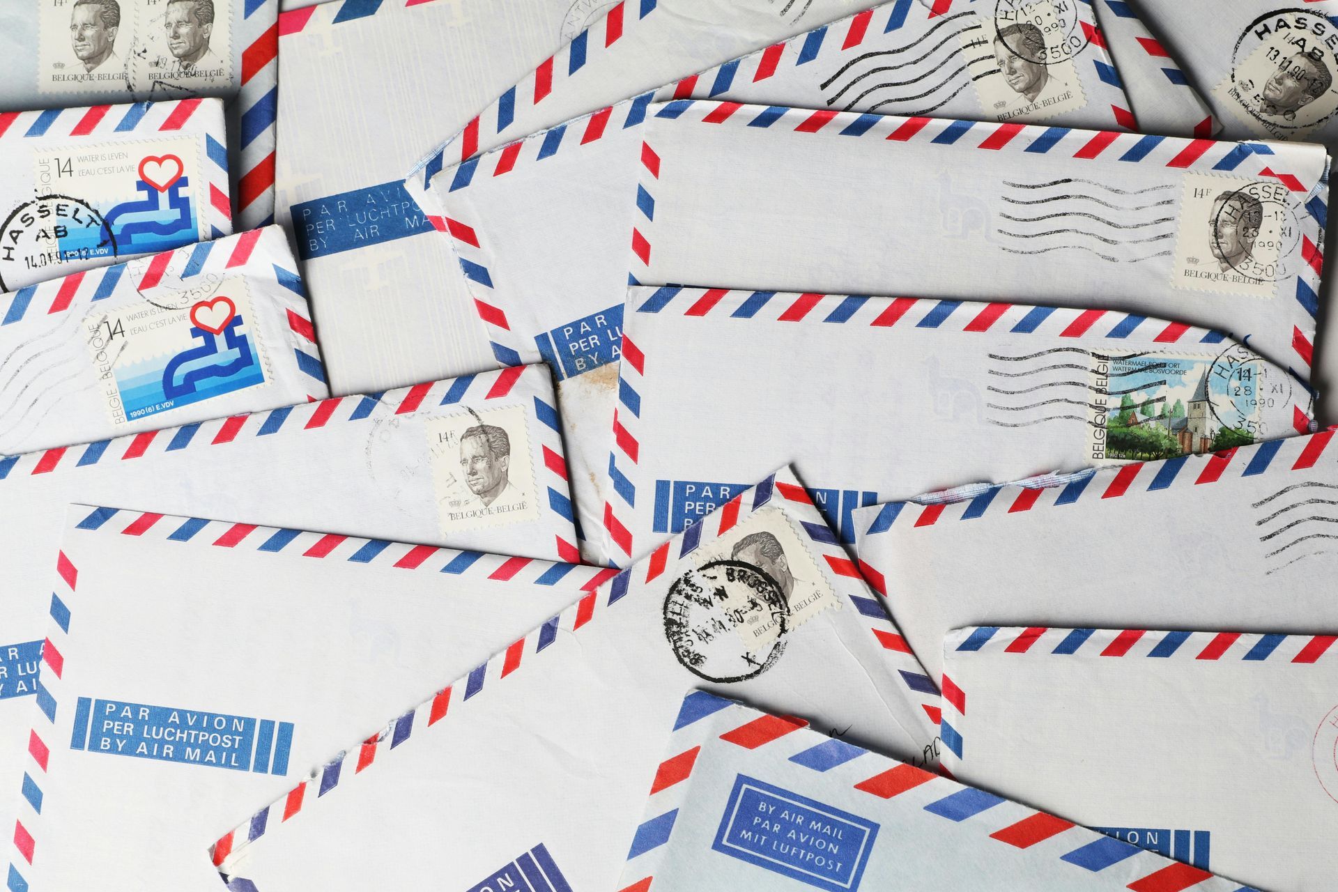 Airmail envelopes with red and blue stripes, various stamps visible.