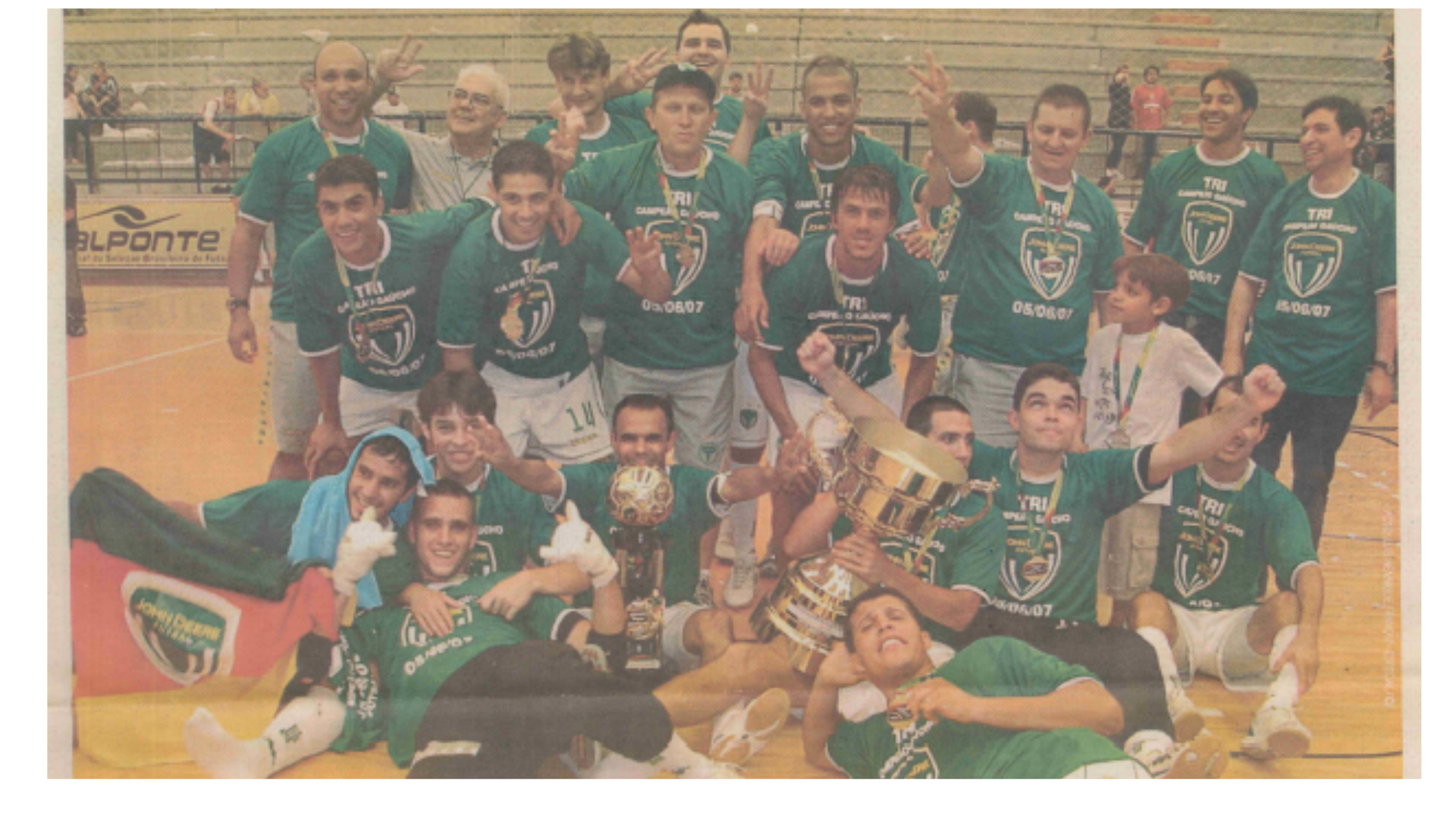 Grupo de jogadores está posando para uma foto com dois troféus e medalhas.