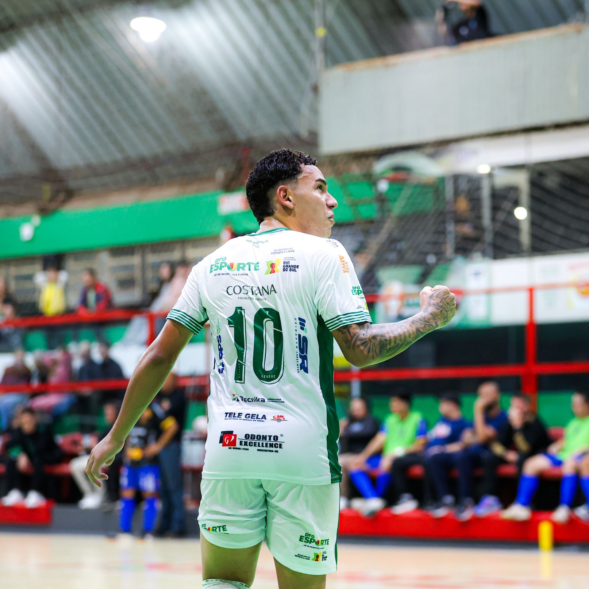 Um grupo de jogadores de futebol se abraçam na quadra
