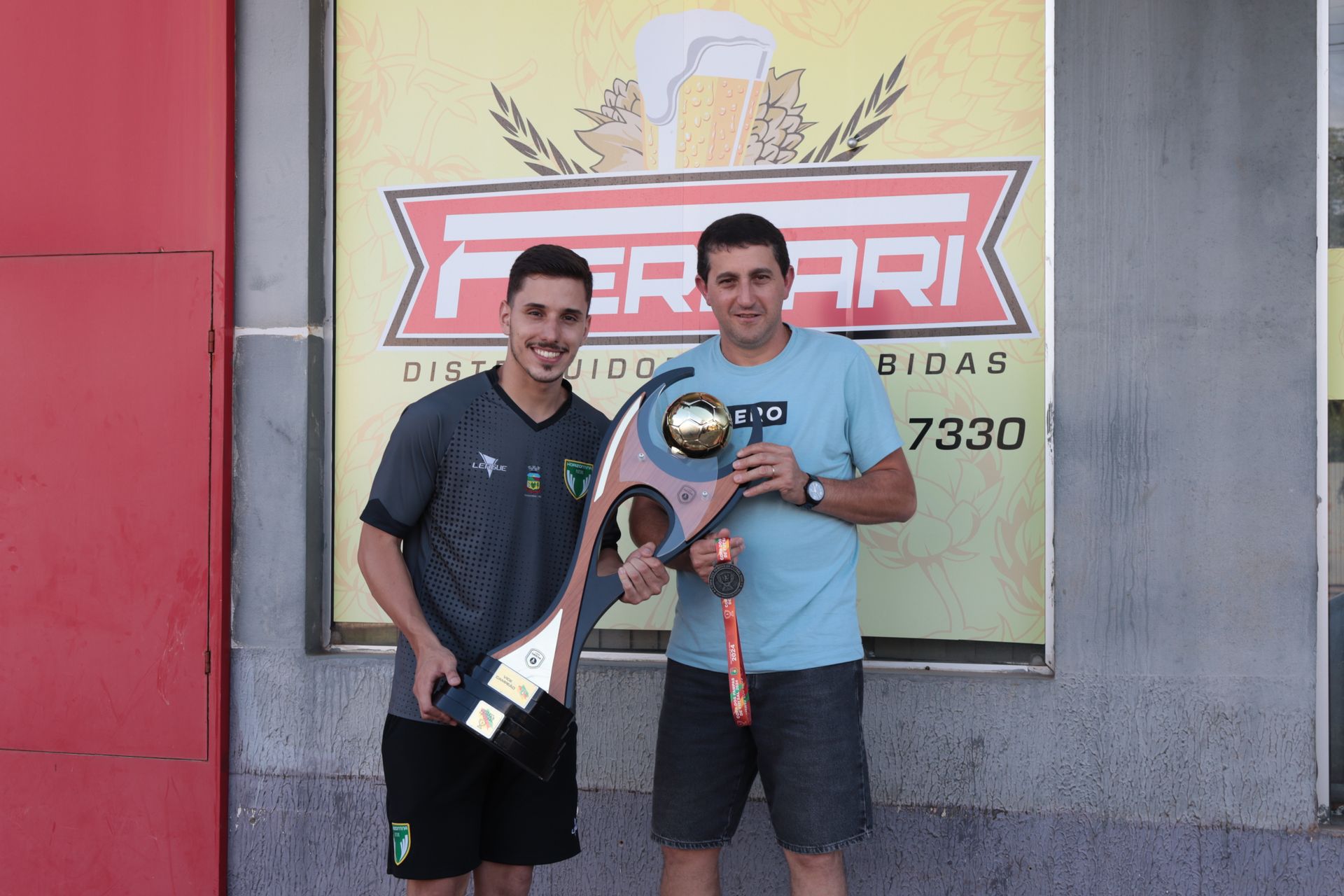 Dois homens parados em frente a uma placa que diz ferrari