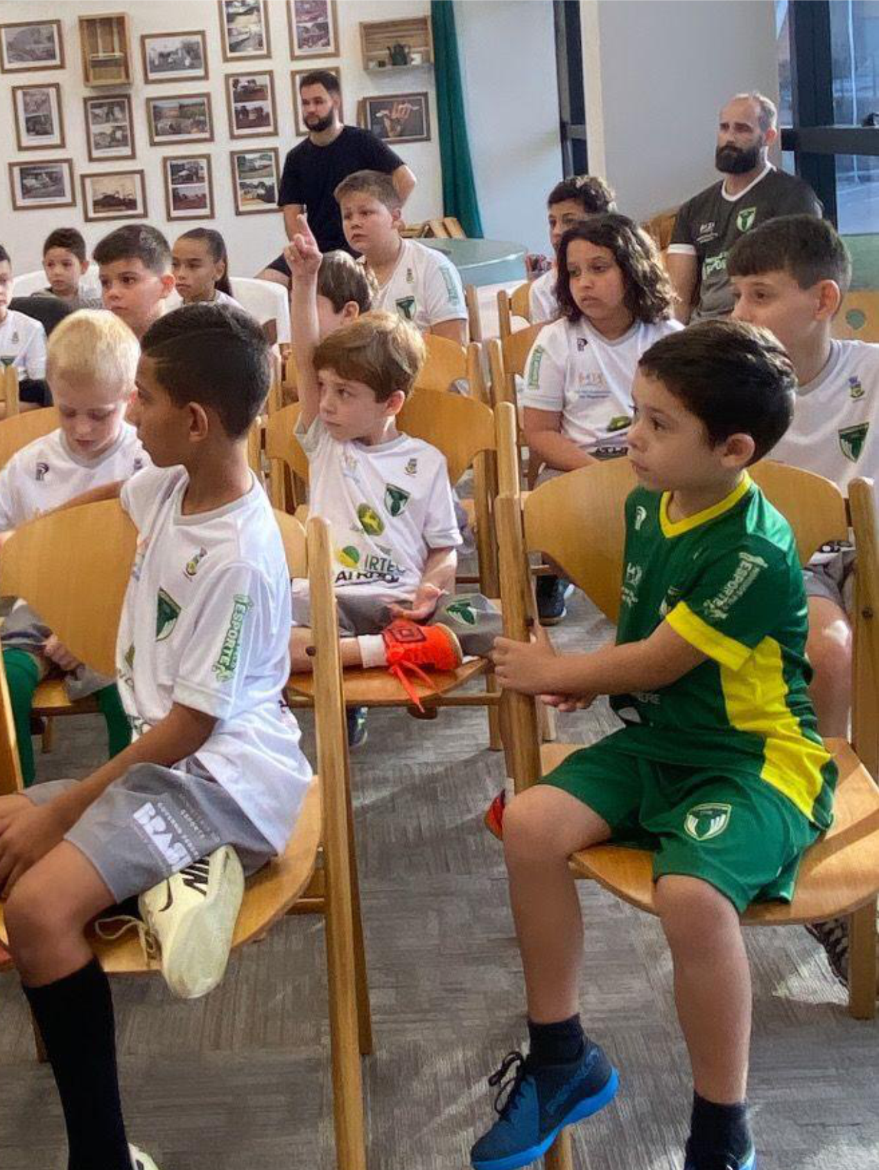 Um grupo de crianças está sentado em cadeiras em uma sala.