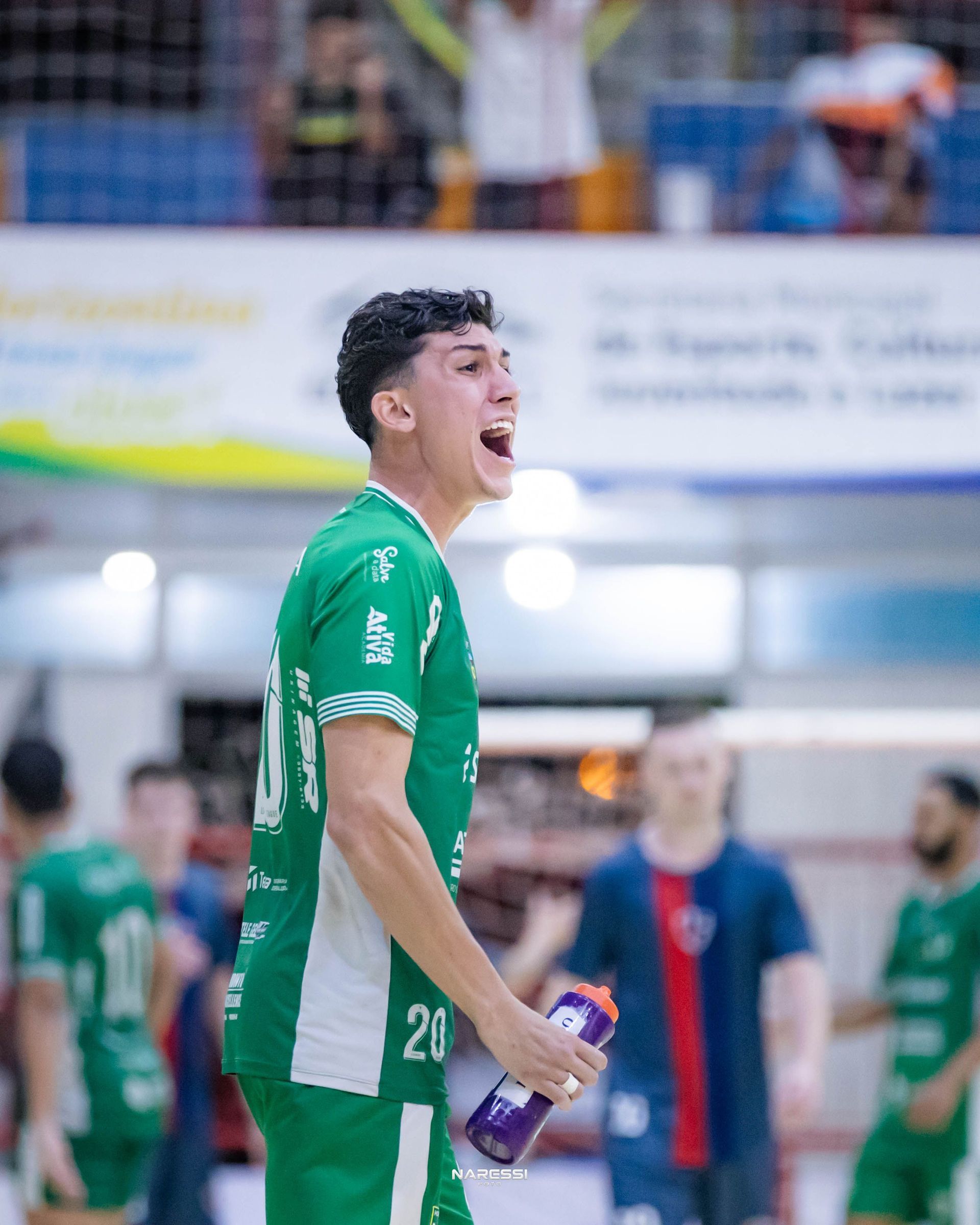 Jogador abraçando e comemorando com torcedor no ginásio.