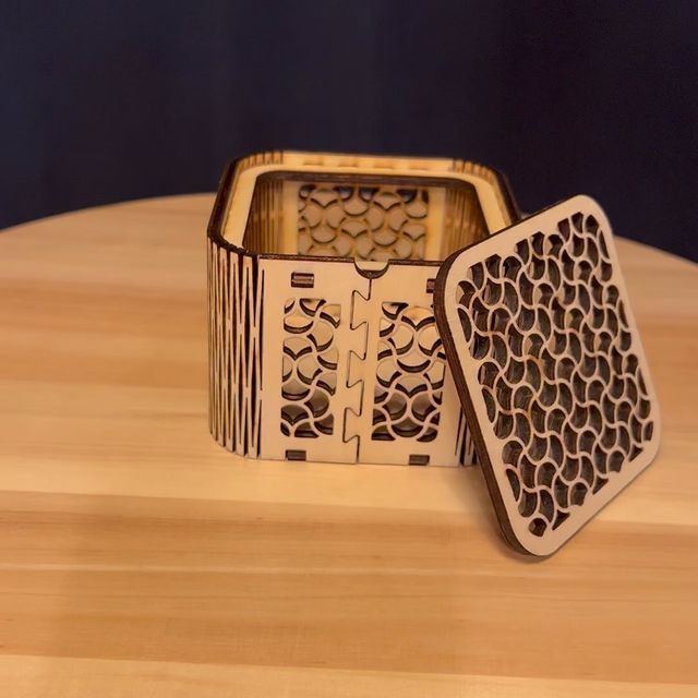 Eine Holzkiste mit offenem Deckel steht auf einem Holztisch