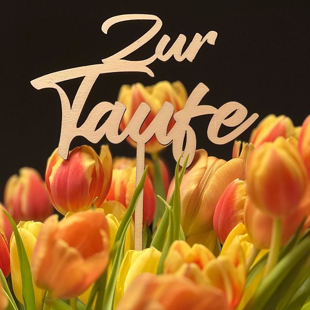 Ein Blumenstrauß mit einem Schild mit der Aufschrift „Zur Taufe“