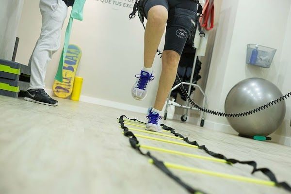 Une personne saute par-dessus une échelle dans une salle de sport.