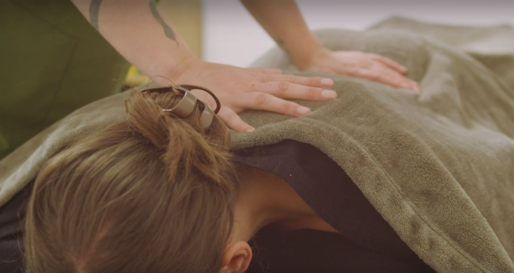 Une femme est allongée sur le dos et reçoit un massage.