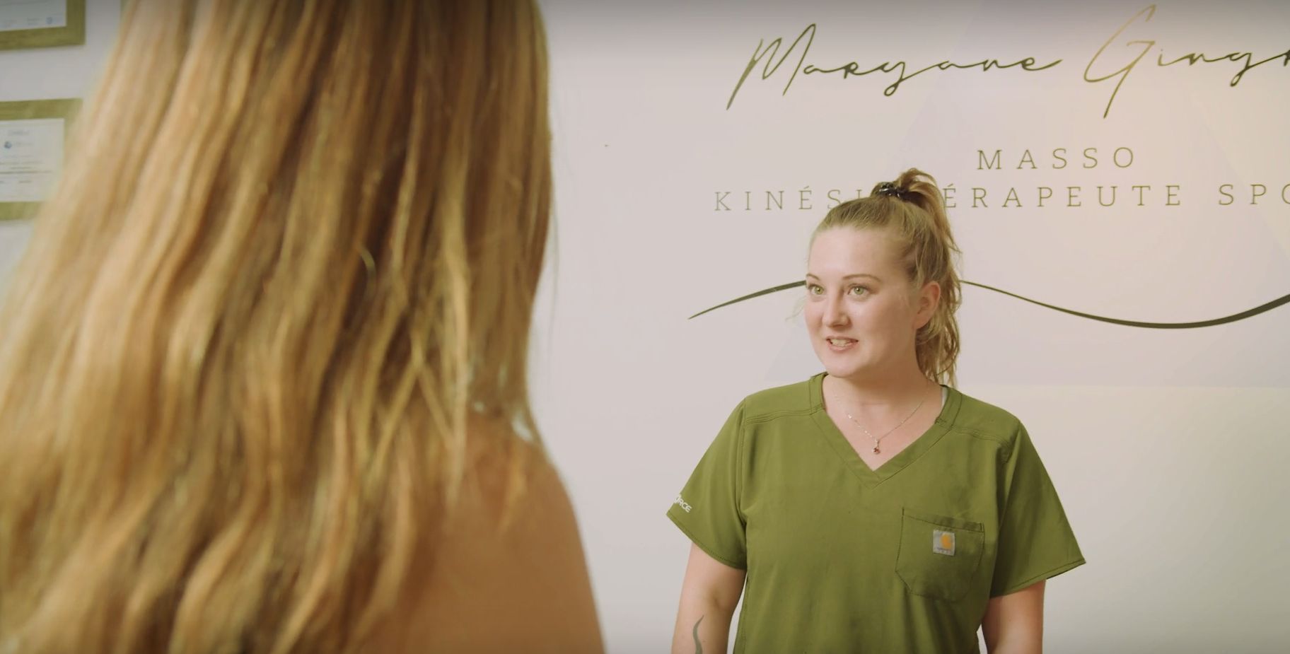 Une femme vêtue d'un haut vert parle à une autre femme.