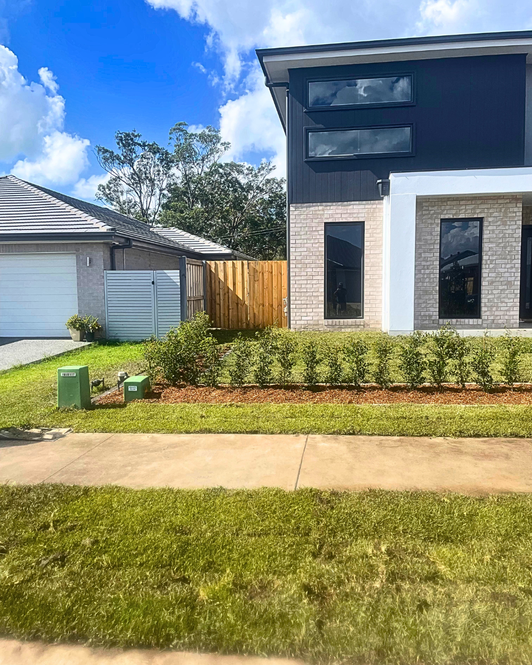 A house with a lawn and a truck parked in front of it.