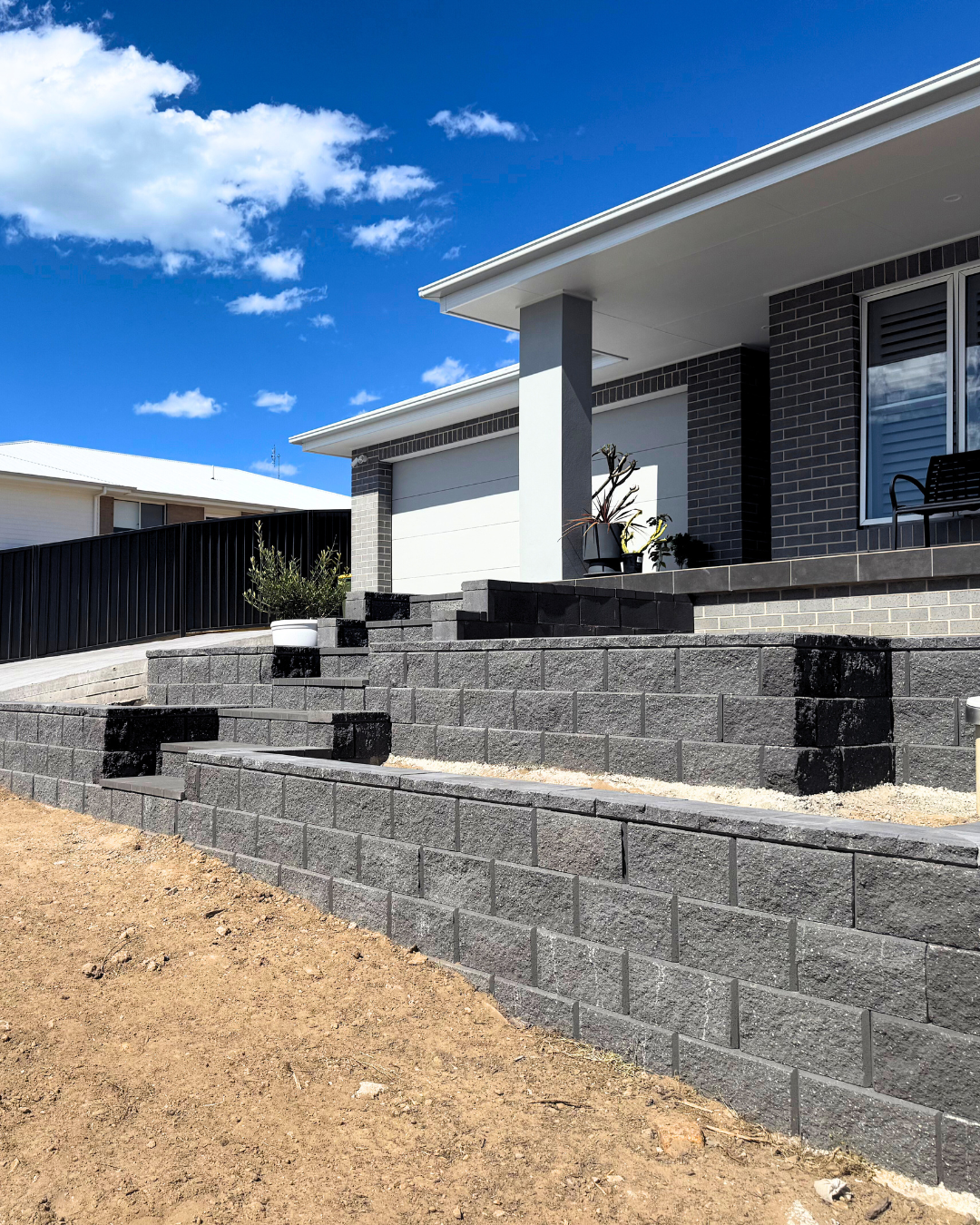 A concrete walkway leading to a house in a residential area.