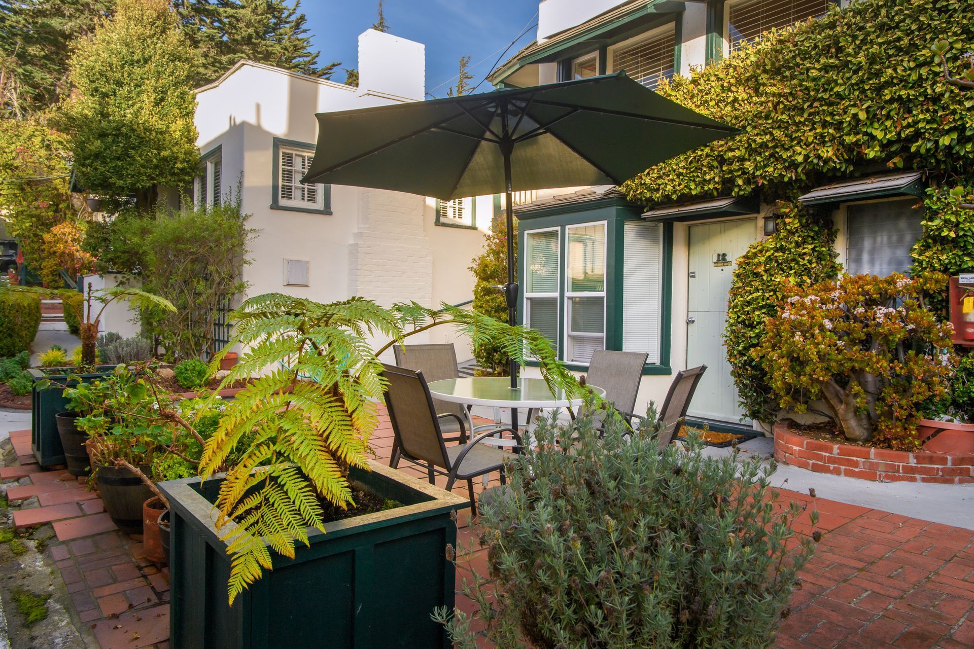 A patio with a table and chairs under an umbrella