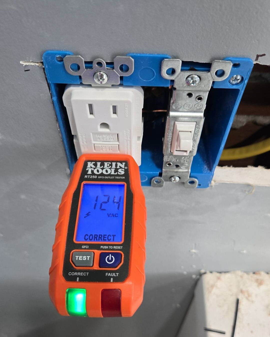 A klein tools device is plugged into a wall outlet