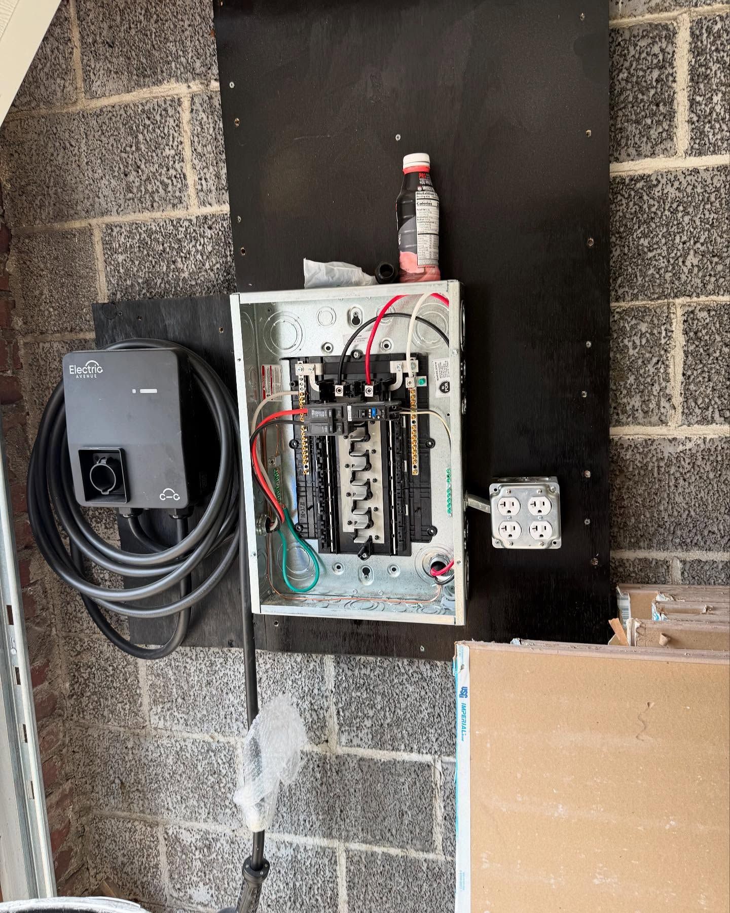 A electrical box is hanging on a brick wall.