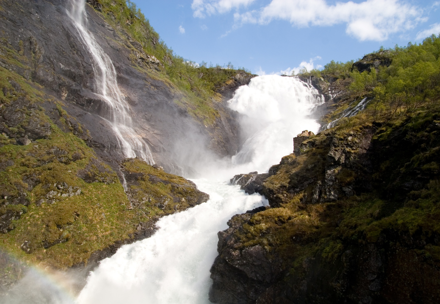 Een waterval die langs de zijkant van een berg naar beneden stroomt.