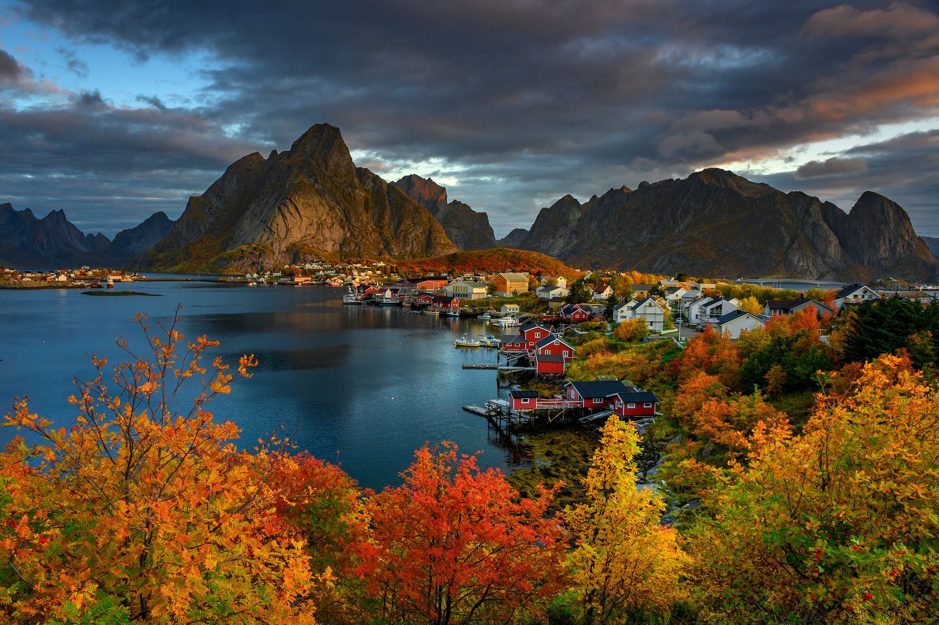 Bergen met uitzicht op een kustplaatsje, bedekt met herfstkleuren.