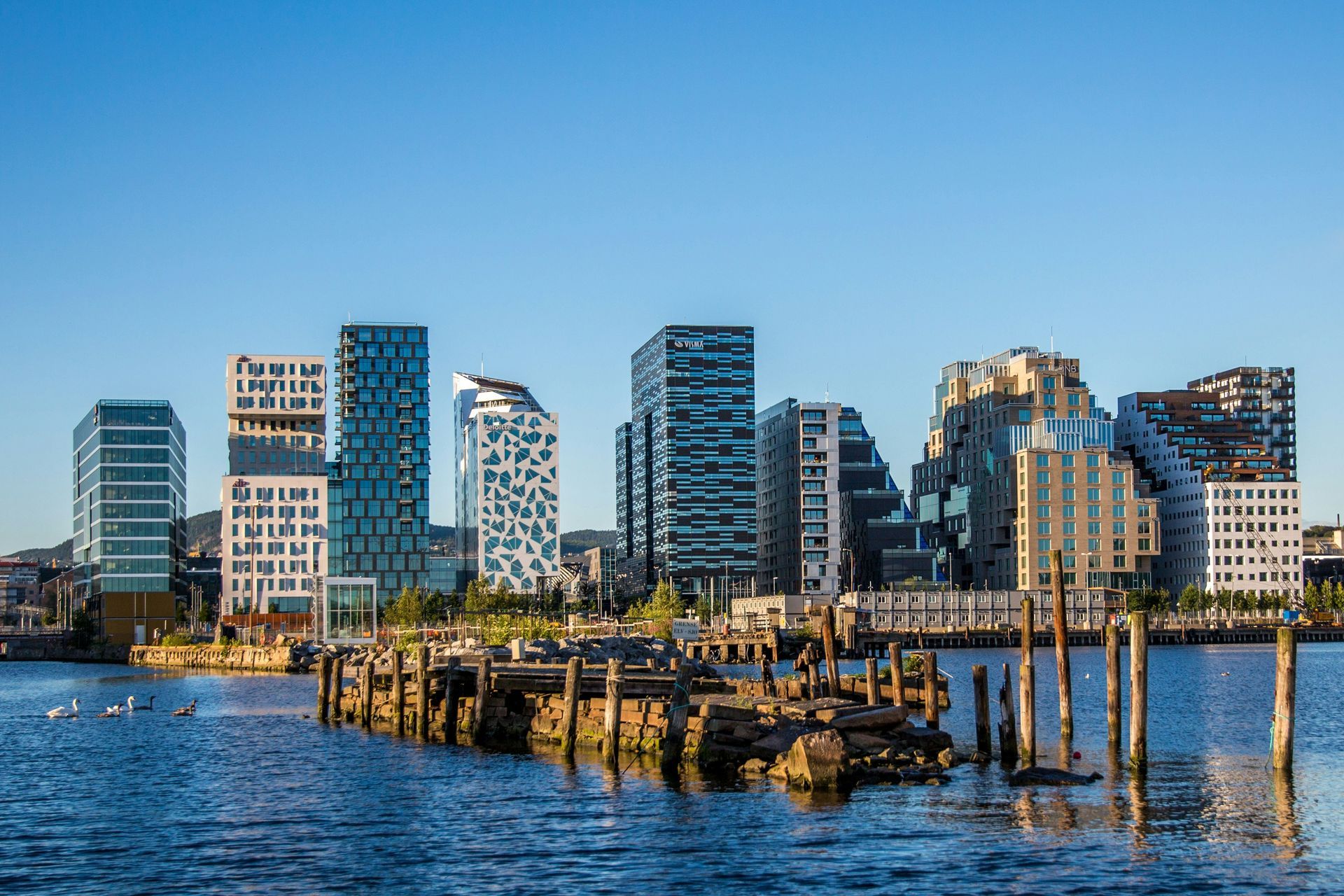 Een skyline van een stad met een watermassa op de voorgrond.