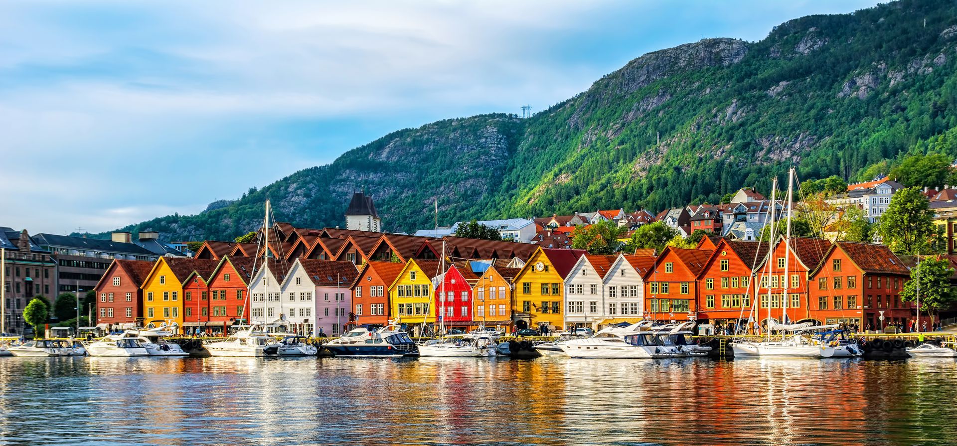 Bryggen in Bergen, Noorwegen, is een straat met een rij kleurrijke, historische houten gebouwen langs de waterkant, met aangemeerde boten.
