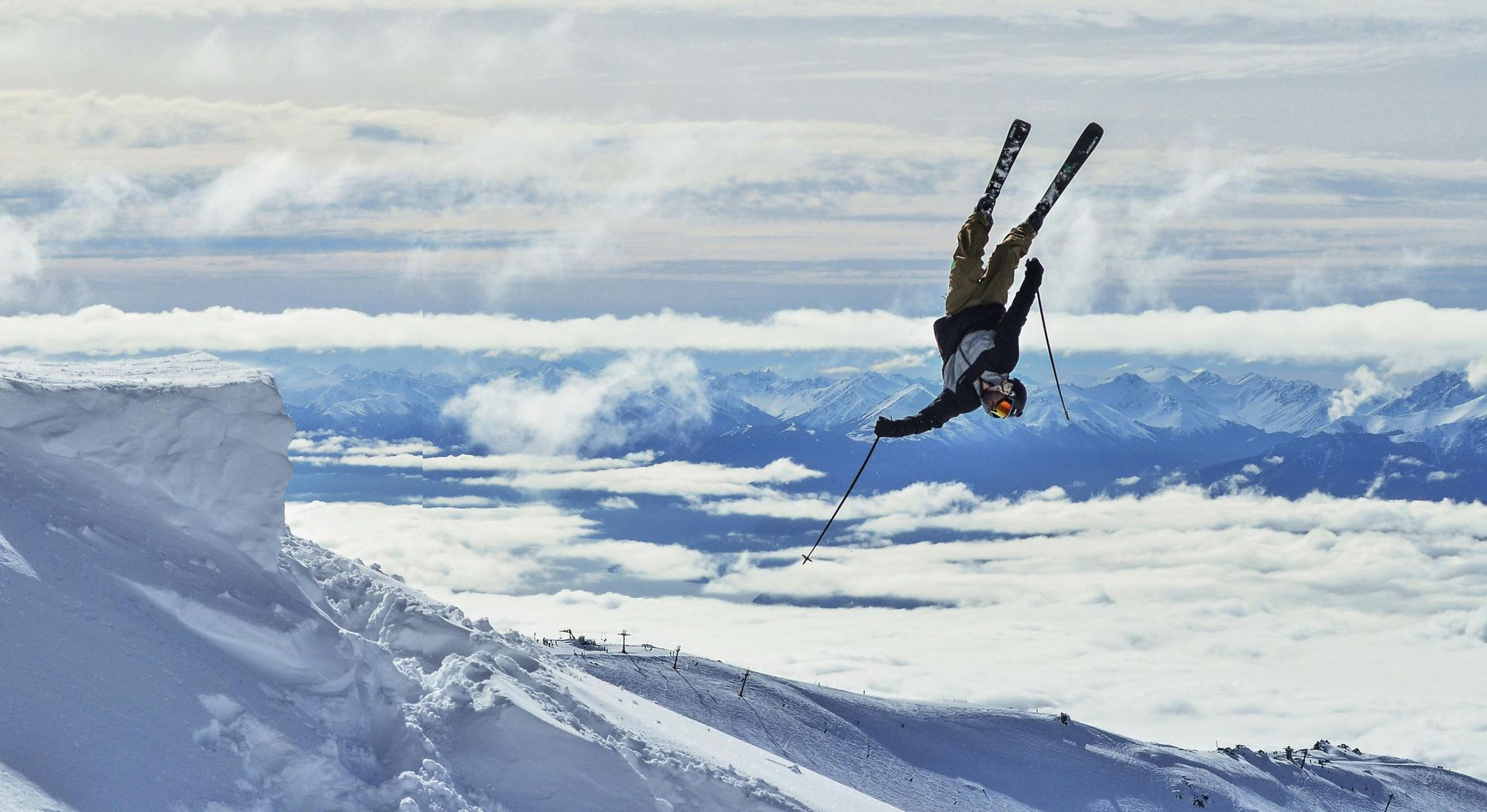 Een persoon doet een truc op ski's in de lucht.