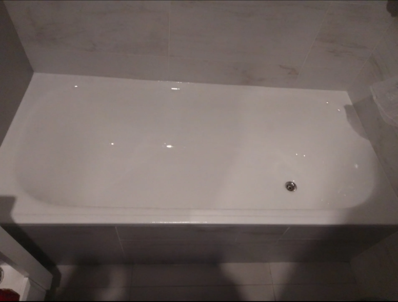 Bañera blanca en un baño alicatado, vista desde arriba.