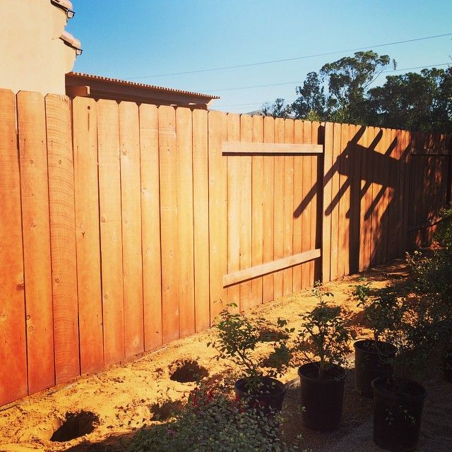 A wooden fence is sitting on top of a lush green field.