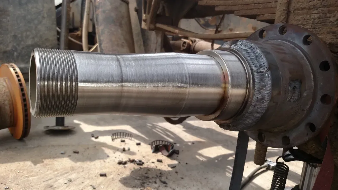 A large metal pipe is sitting on a table in a factory.