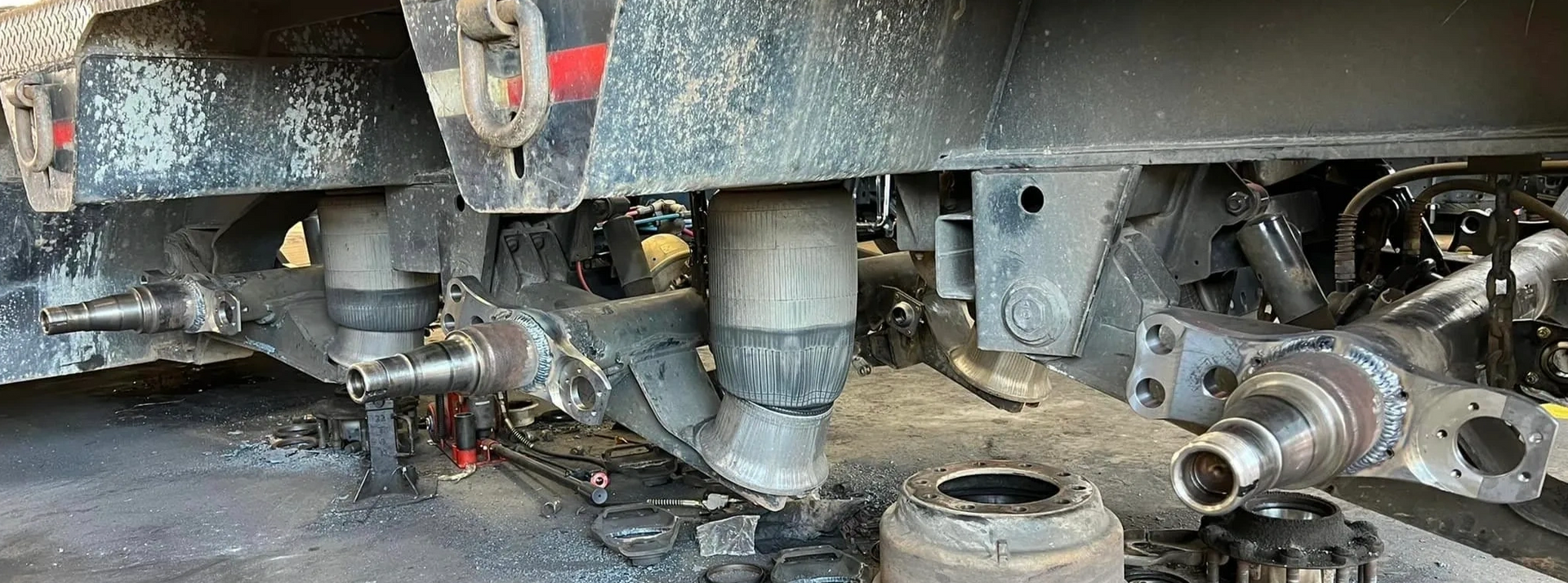 A close up of the underside of a truck being repaired in a garage.