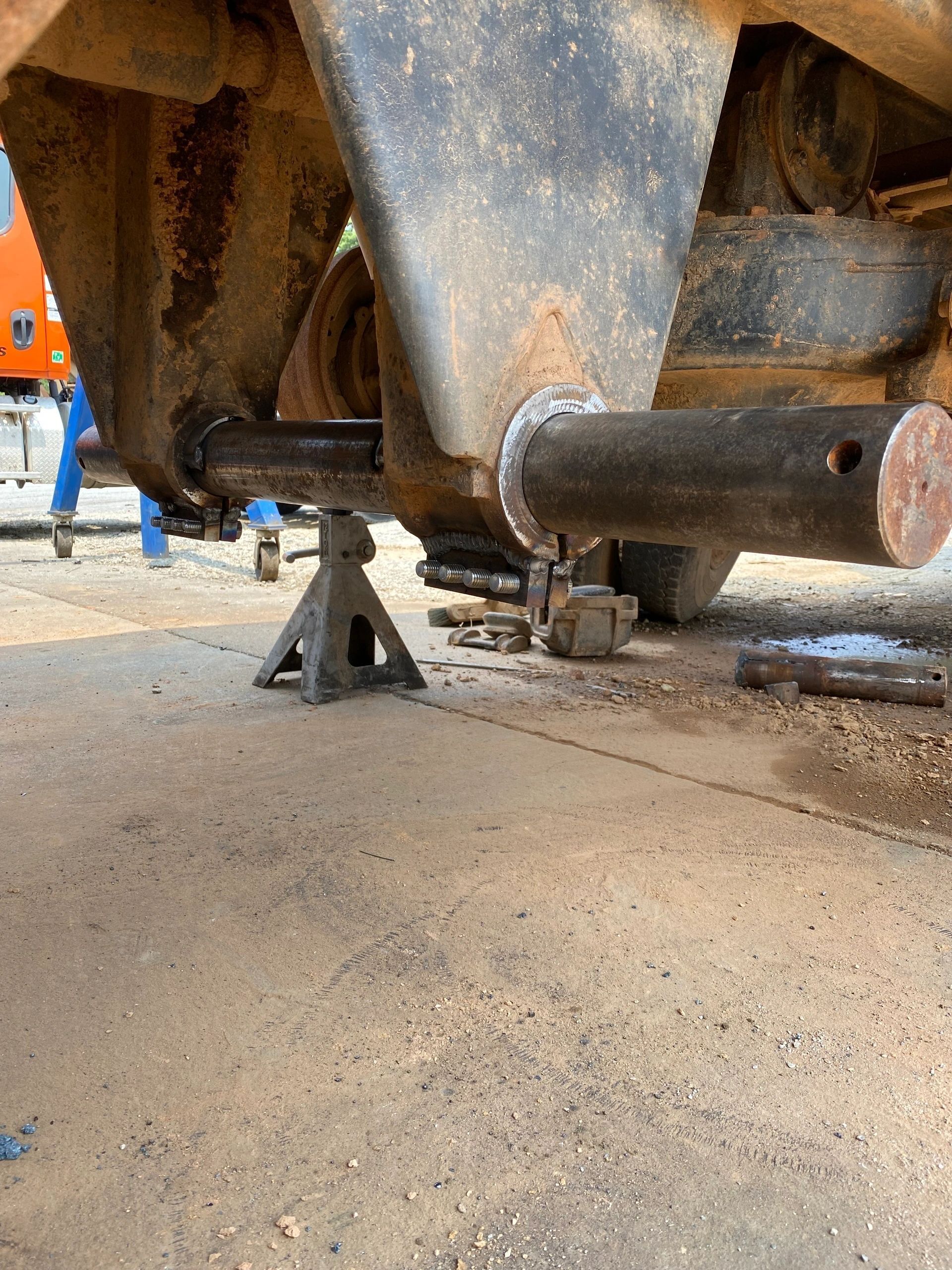 A truck is sitting on a jack stand in a garage.
