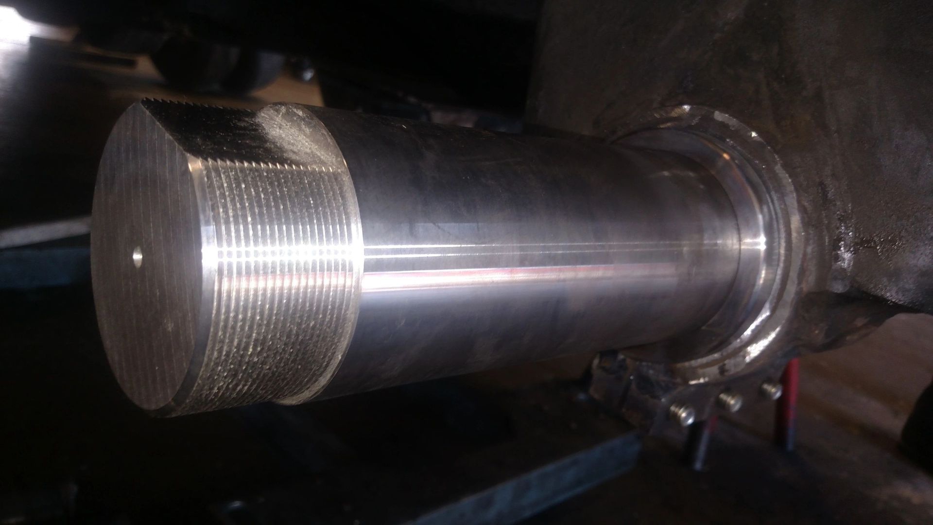 A large metal cylinder is sitting on a table in a dark room.