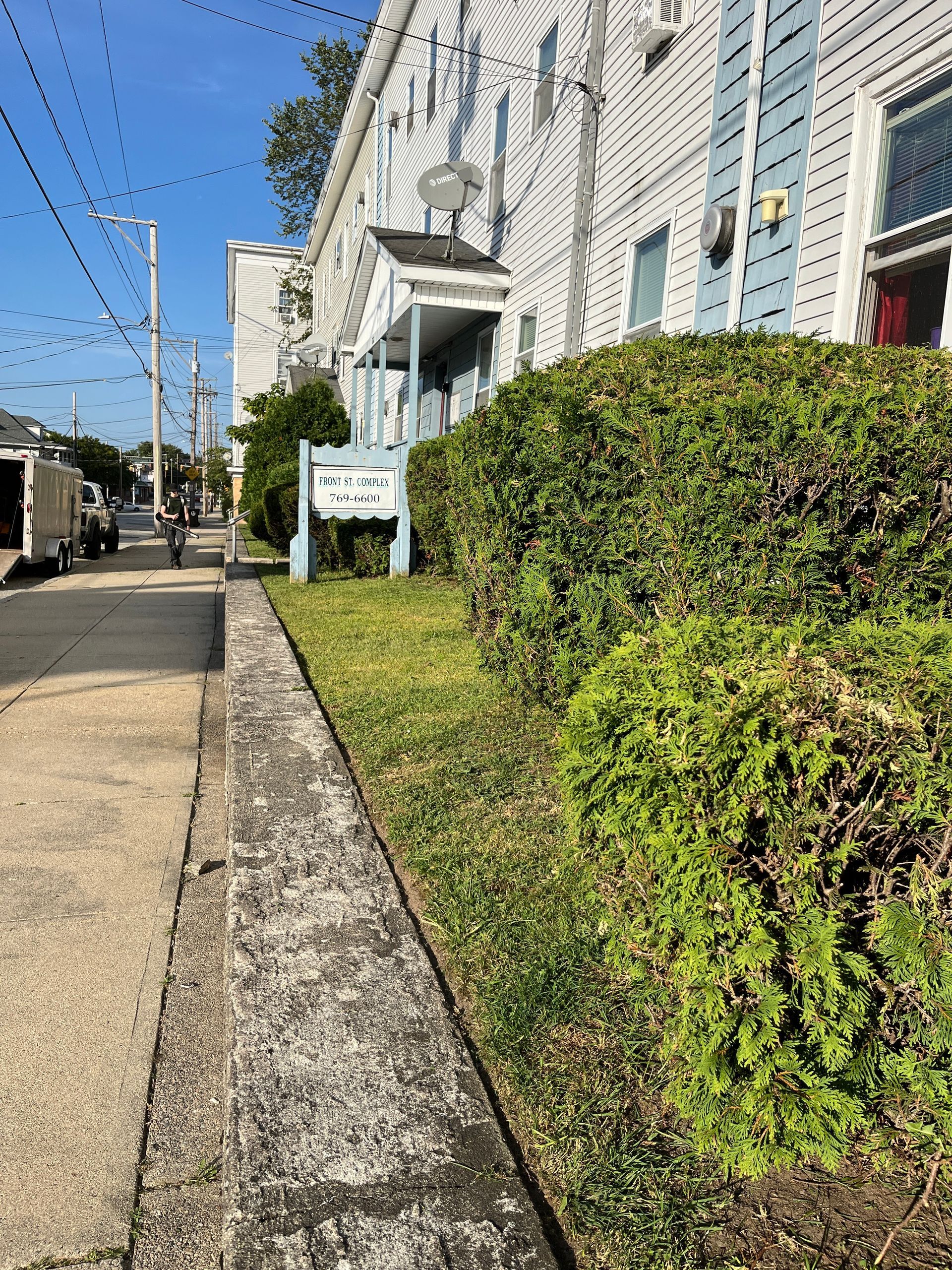 A sidewalk leading to a building with a sign on the side of it.