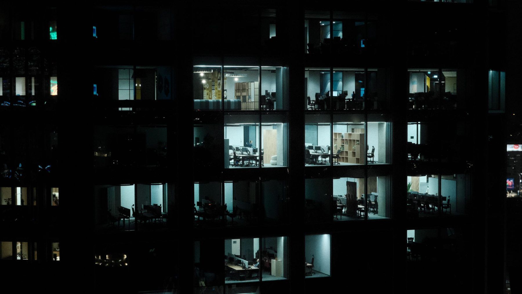 An office tower at night with most of the windows still lit