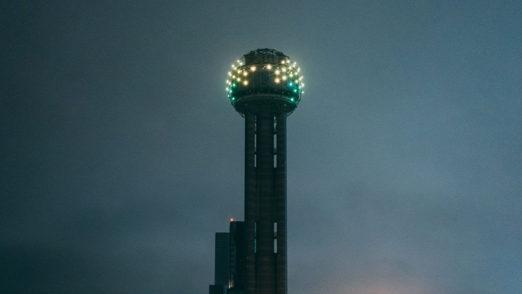 Reunion Tower lit against a hazy Dallas sky at dusk