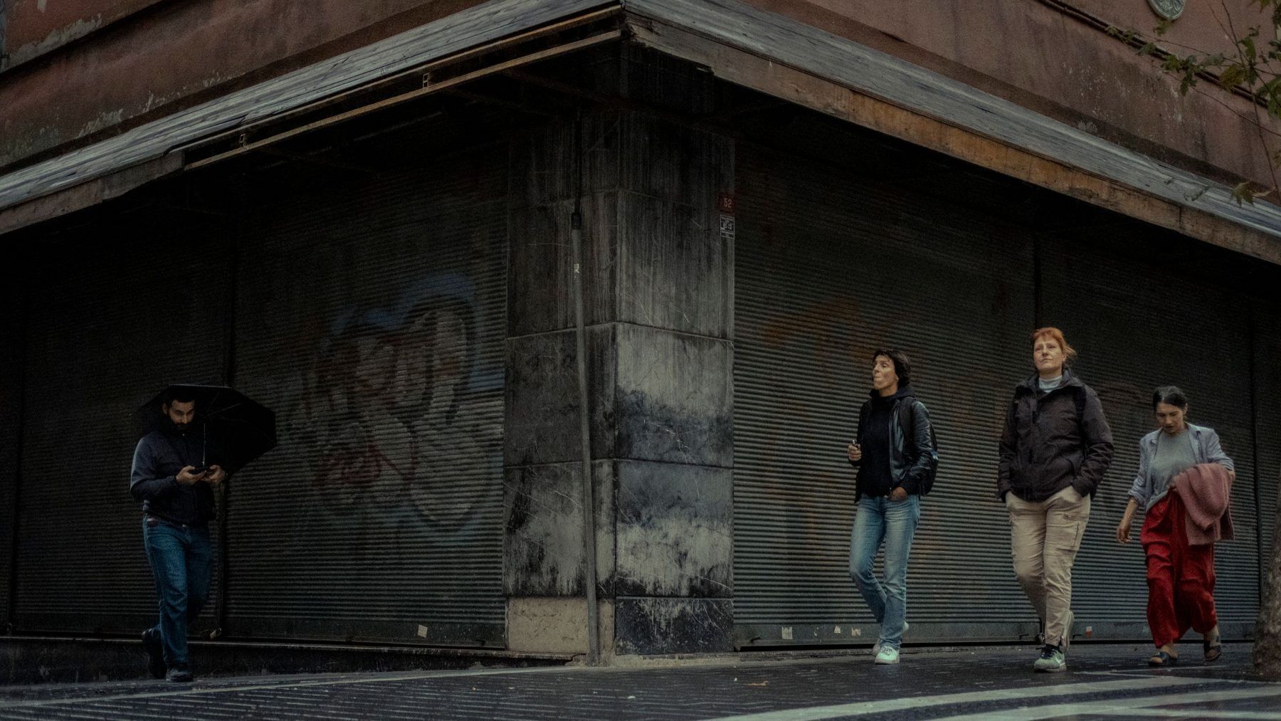 People walking past a shuttered storefront